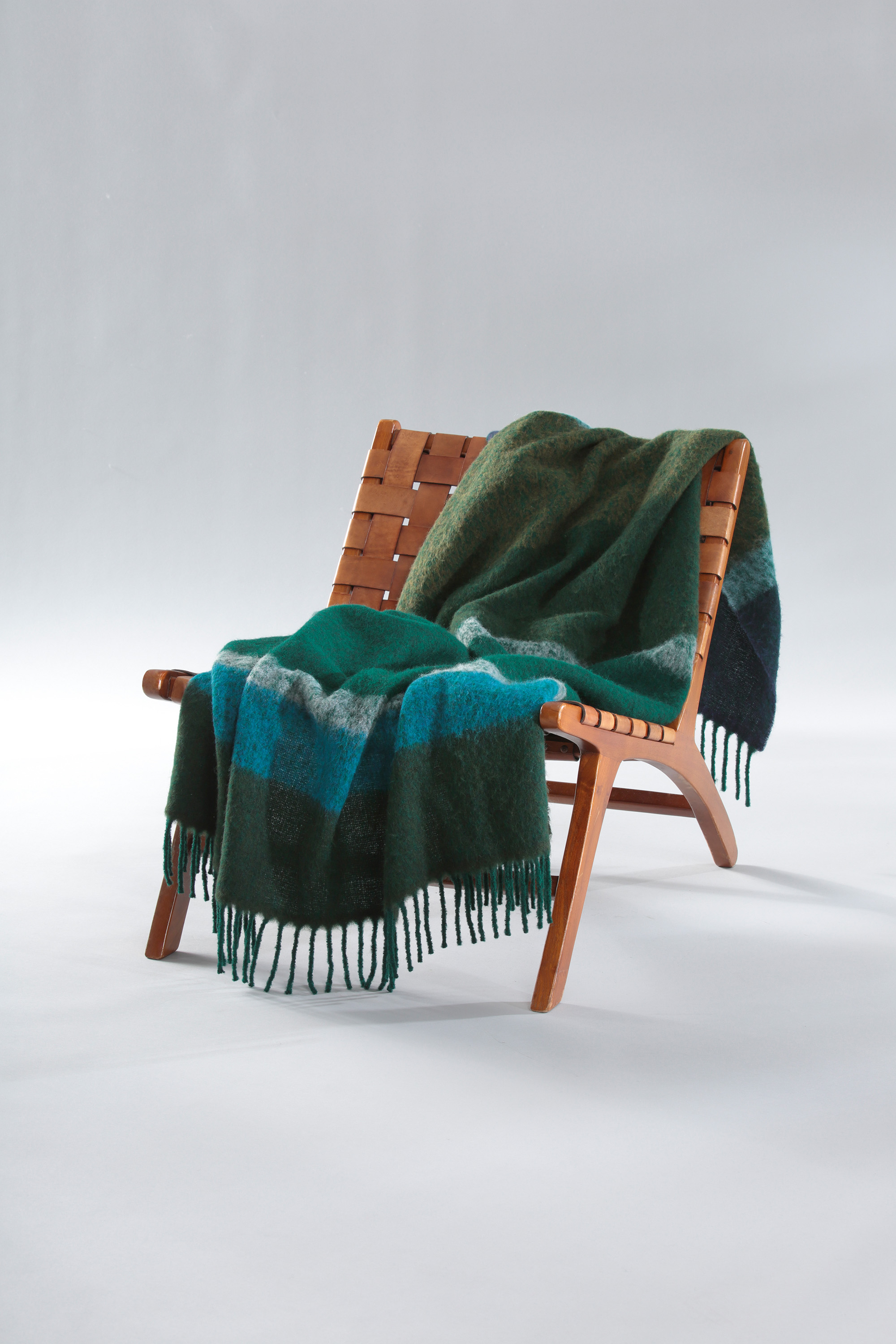 Fransenplaid Mohair Look Emerald auf Sessel gelegt