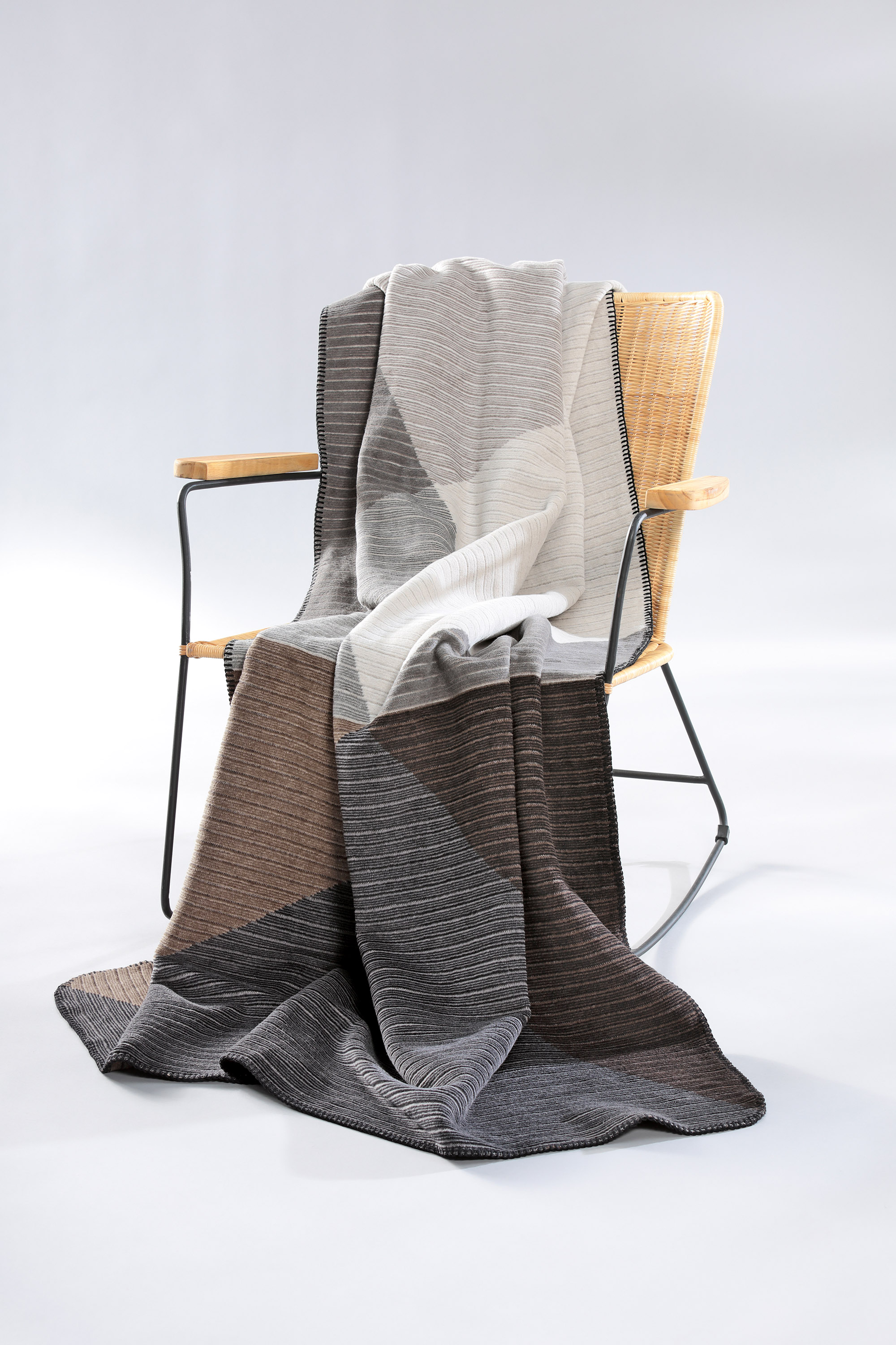 Wohndecke mit Reliefstruktur Feel Graphic auf Sessel gelegt