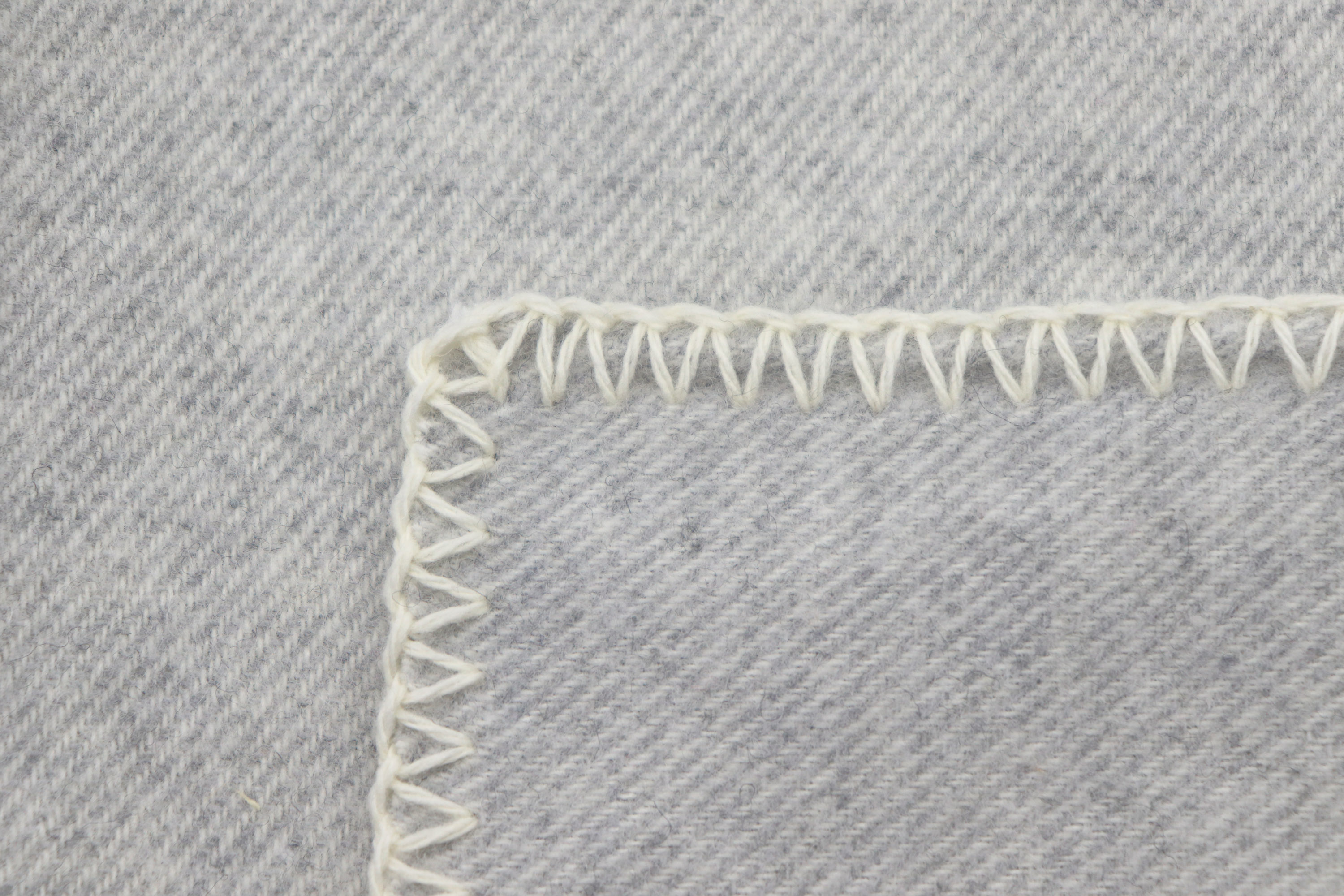 Wohndecke aus recycelter Wolle "Light Wool" Leichte Wolldecke aus Recycling-Garn "Light Wool - light grey" - Detailaufnahme Einfassung