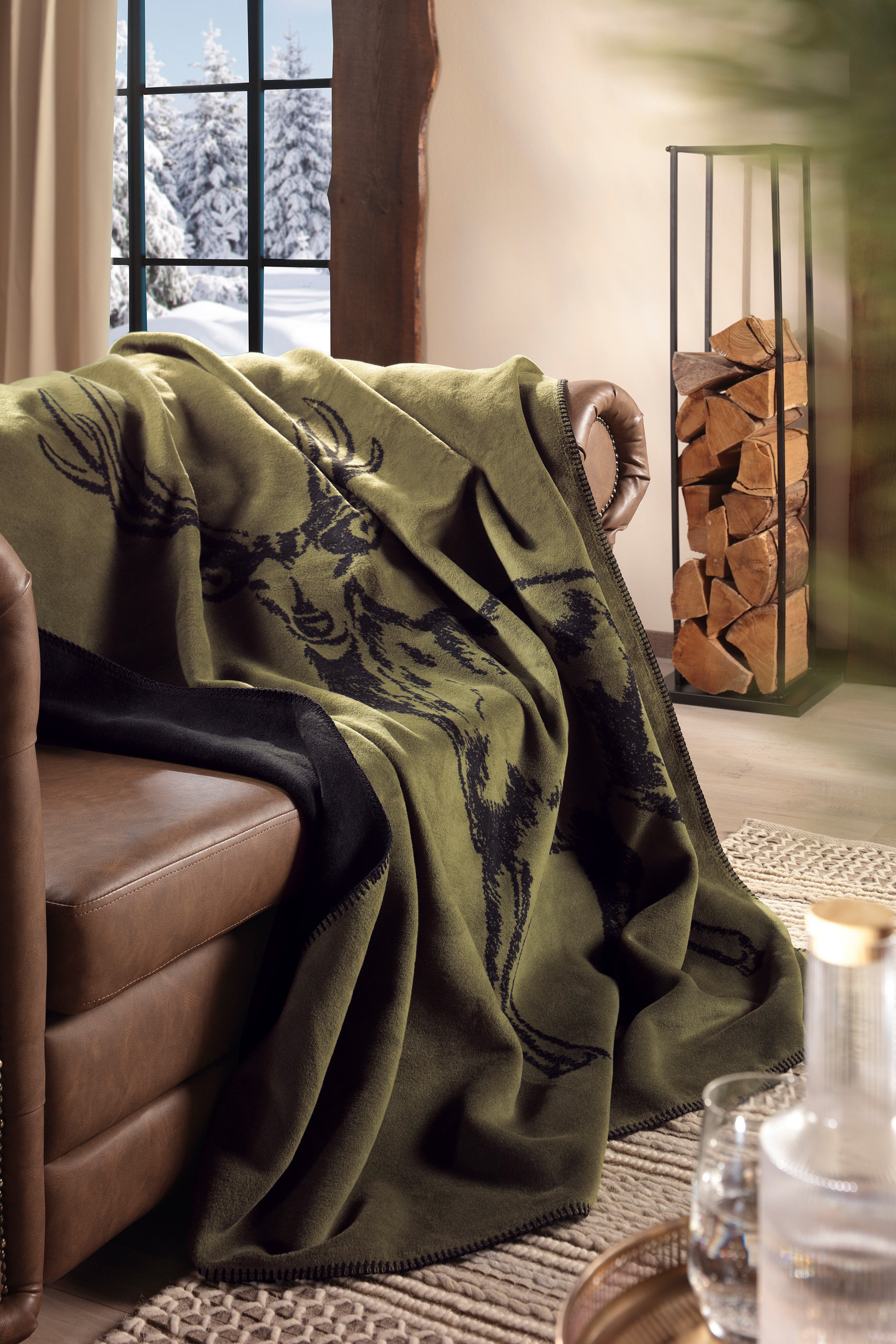Wohndecke Deer Green auf Sofa liegend
