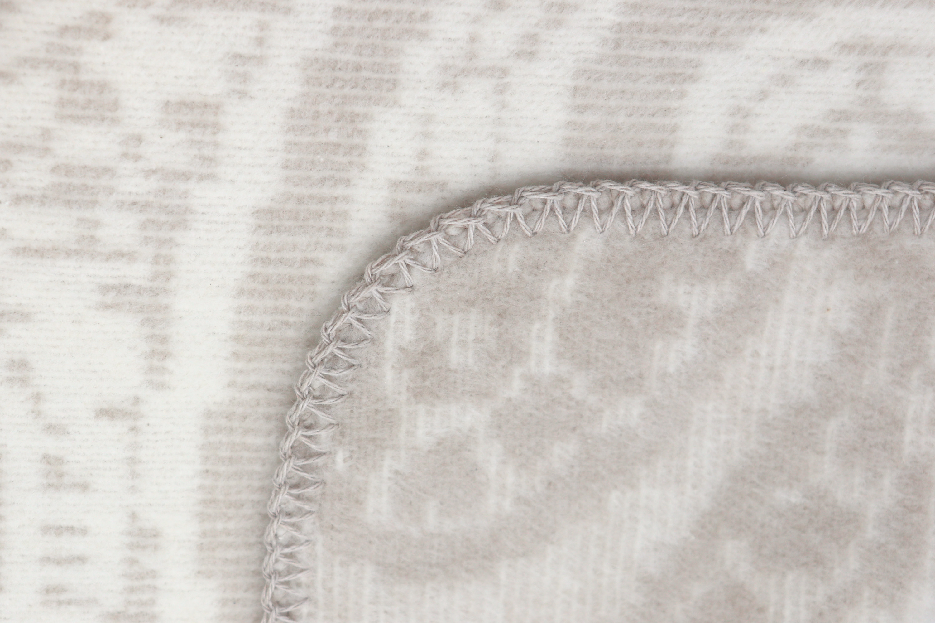 beige Wohndecke "Swinging Paisley" in 150x200 cm - Detailaufnahme Zierstich