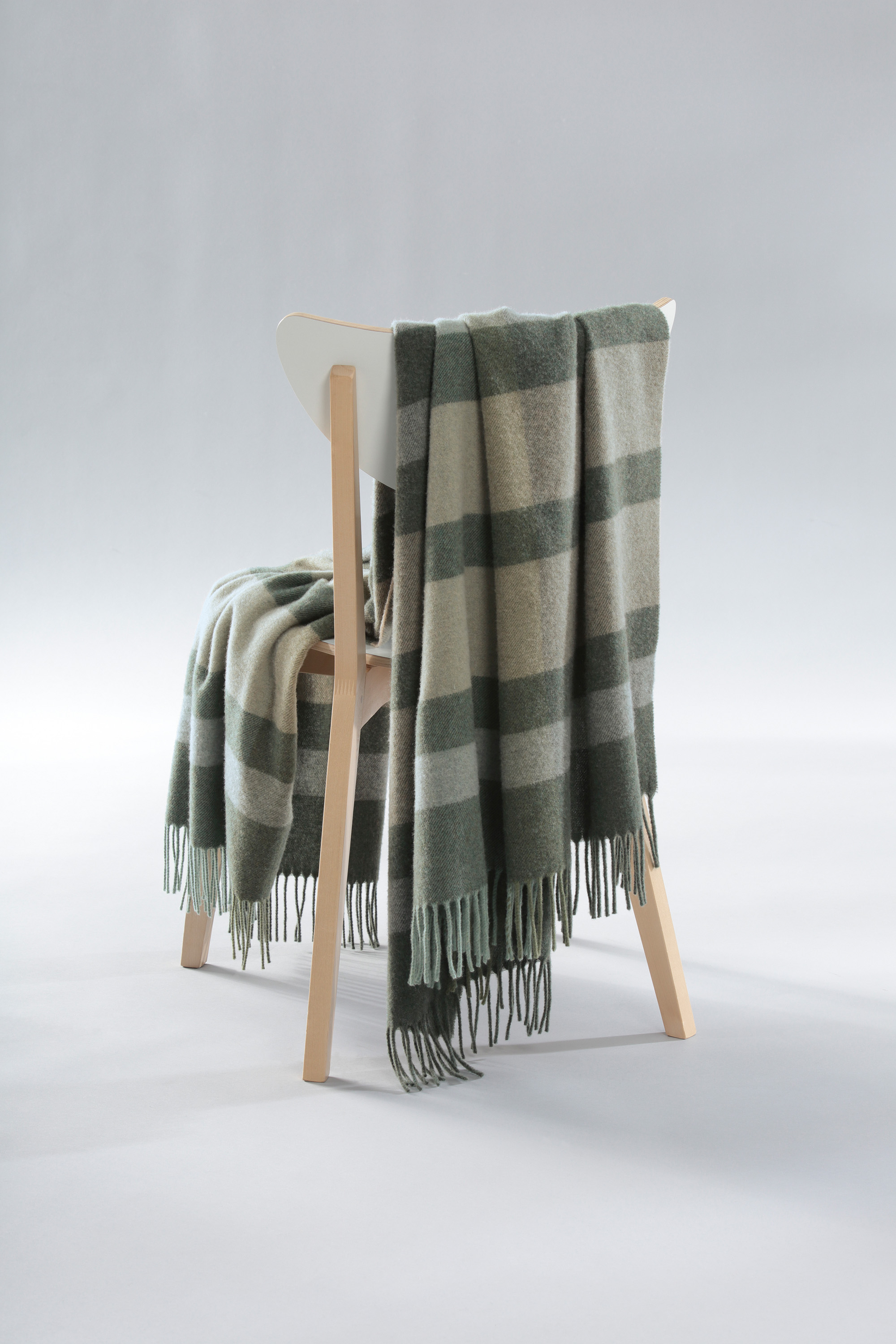 Kaschmirplaid Moss Charming auf Stuhl gelegt